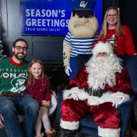 Parents and sisters smile with Santa and Louie